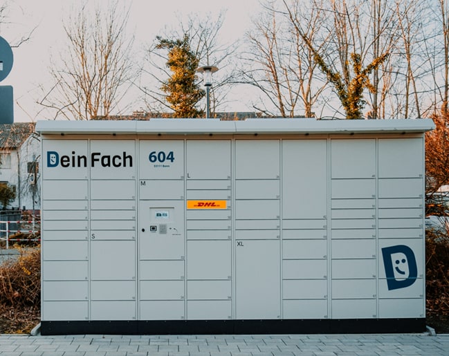 Aktiver DeinFach Paketautomat an einem Outdoor-Standort mit DHL Logo